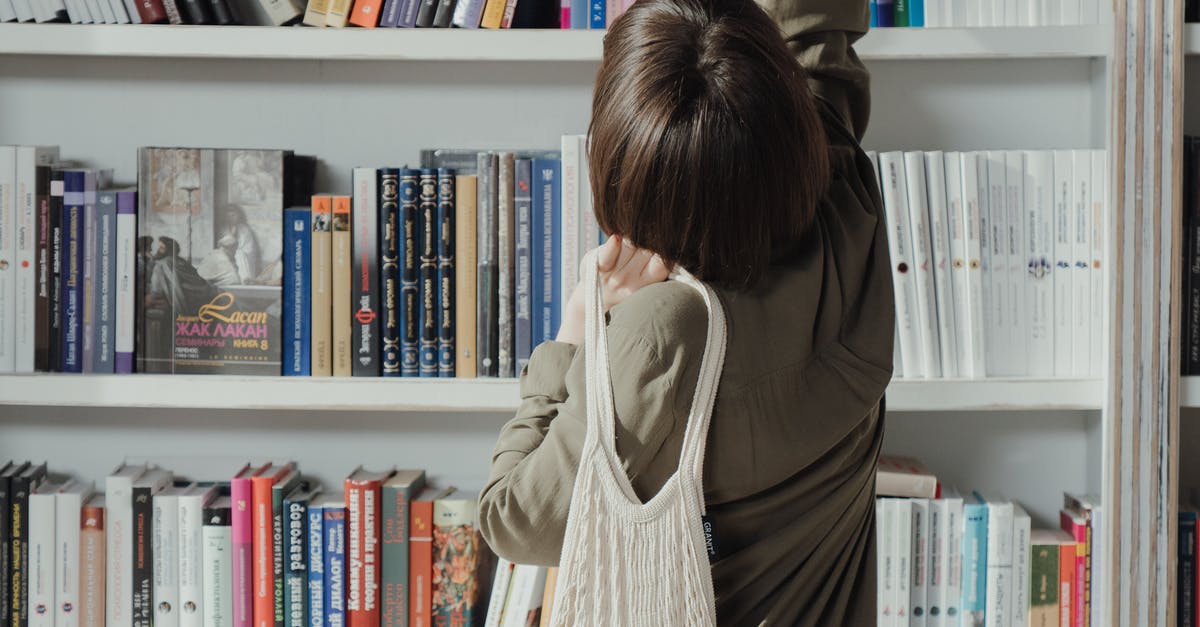A person standing in front of a book shelf